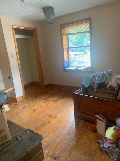 bedroom with a closet, a textured ceiling, and hardwood / wood-style floors