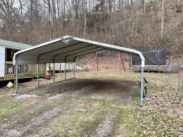 view of parking / parking lot featuring a carport and a trampoline