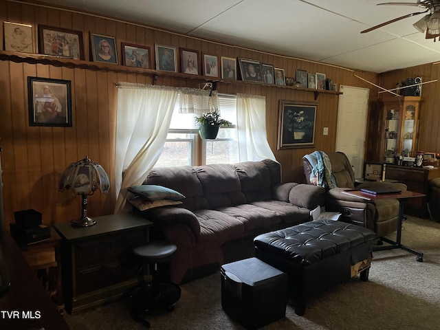 living room with carpet floors, ceiling fan, and wooden walls