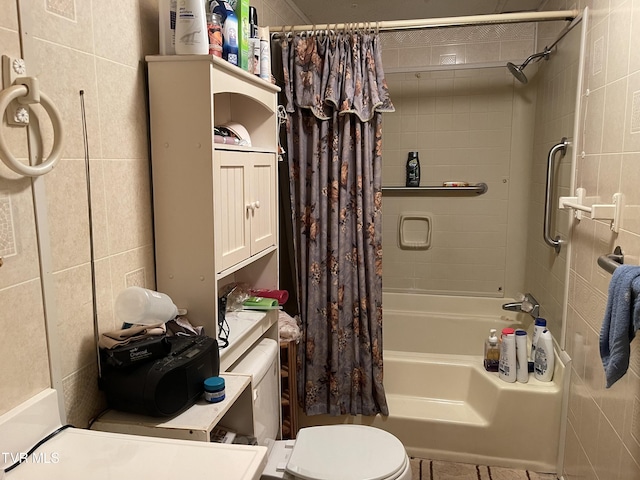 bathroom featuring tile walls, shower / bath combo, and toilet