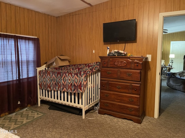 carpeted bedroom with wood walls