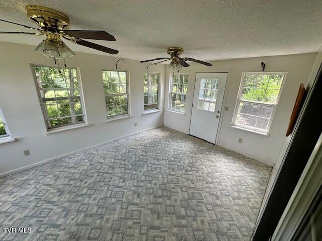 interior space with a textured ceiling and ceiling fan