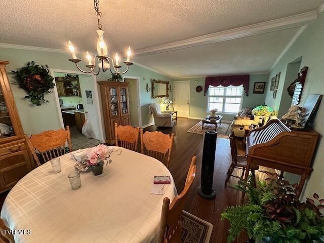 dining room with hardwood / wood-style flooring, a notable chandelier, crown molding, and a textured ceiling