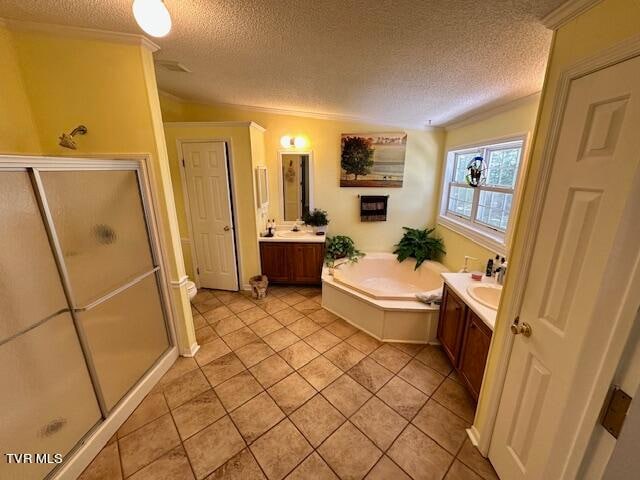 bathroom featuring independent shower and bath, tile patterned floors, vanity, and a textured ceiling