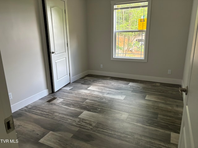 empty room with a healthy amount of sunlight and hardwood / wood-style flooring