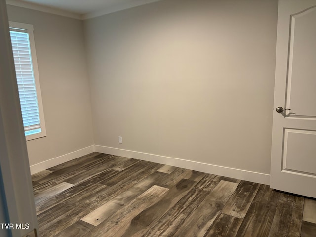 empty room with dark wood-type flooring and ornamental molding