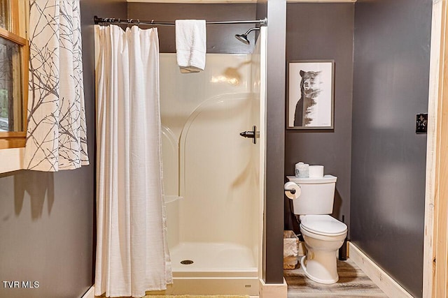 bathroom with toilet, wood-type flooring, and a shower with shower curtain