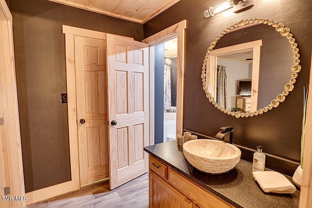 bathroom with hardwood / wood-style floors, vanity, and wooden ceiling