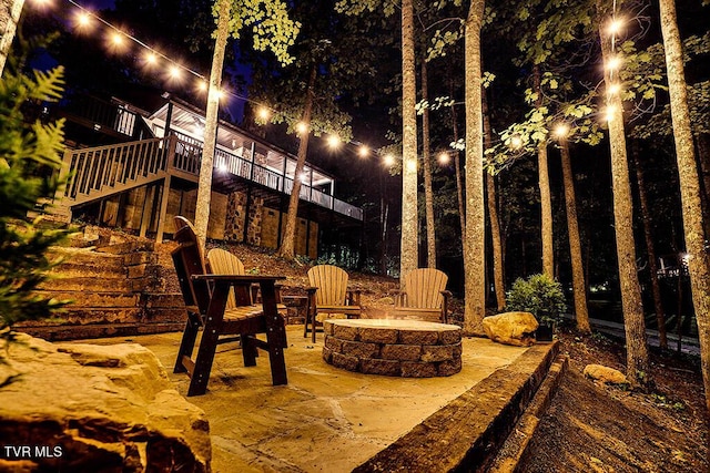 patio at night featuring a fire pit