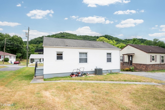 view of front of house featuring a front lawn and cooling unit