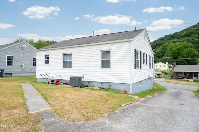 back of house featuring a yard and central AC unit