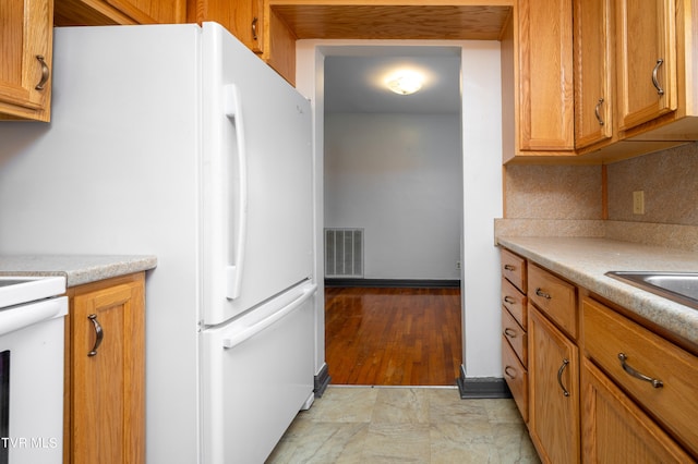 kitchen with light hardwood / wood-style flooring and white refrigerator