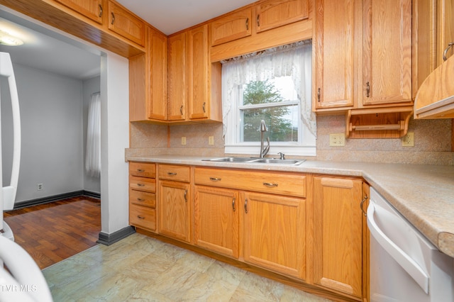 kitchen featuring backsplash, white dishwasher, light hardwood / wood-style flooring, and sink