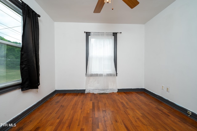 empty room with dark hardwood / wood-style flooring and ceiling fan