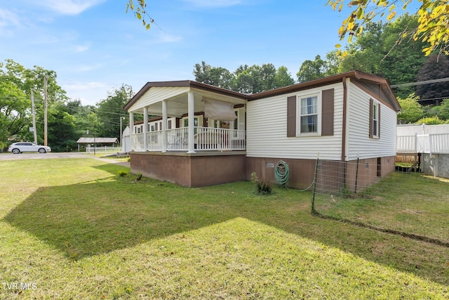 rear view of property with covered porch and a lawn