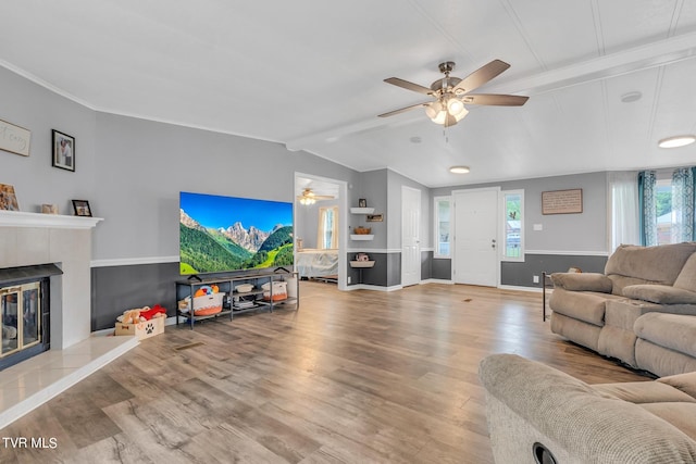 living room with wood finished floors, a ceiling fan, a fireplace, vaulted ceiling with beams, and baseboards