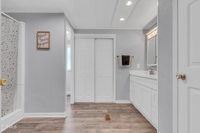 bathroom with a shower with curtain, baseboards, visible vents, vanity, and wood finished floors