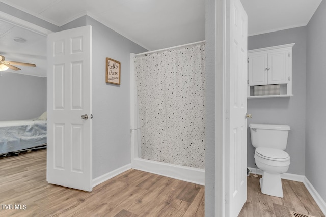 bathroom featuring ornamental molding, curtained shower, ceiling fan, and wood finished floors