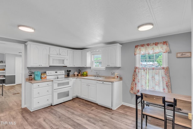 kitchen featuring a wealth of natural light, light wood-type flooring, and white appliances