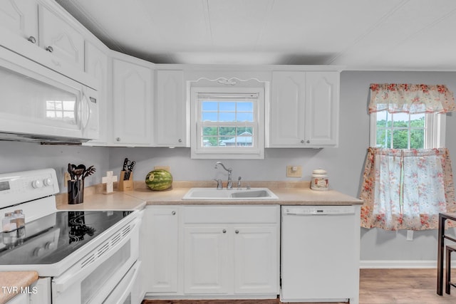 kitchen featuring white cabinetry, a wealth of natural light, white appliances, and a sink