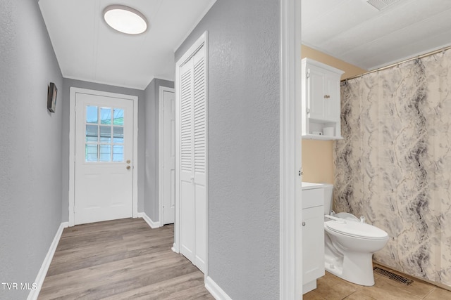 bathroom with wood-type flooring, toilet, and vanity