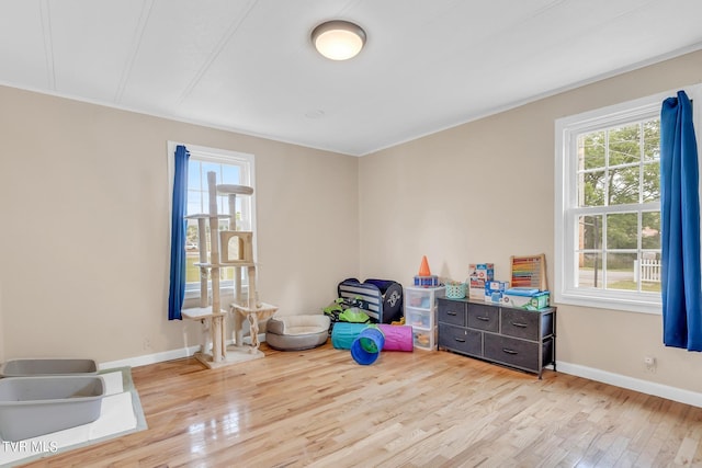 recreation room with baseboards and wood finished floors