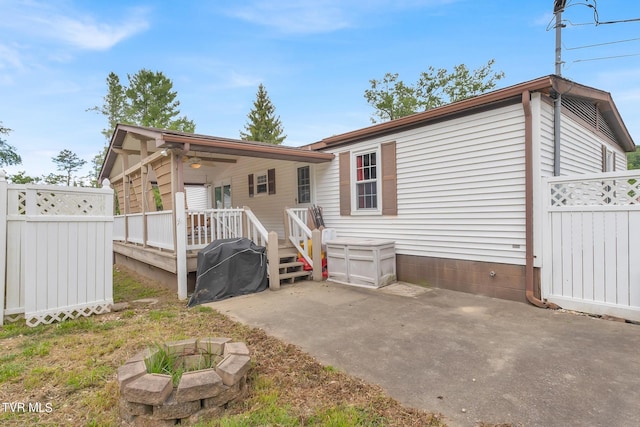 rear view of house featuring an outdoor fire pit, a patio area, a wooden deck, and fence