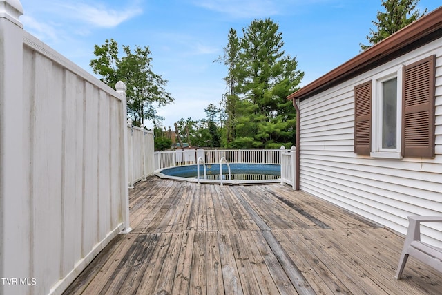 wooden terrace featuring fence and a fenced in pool