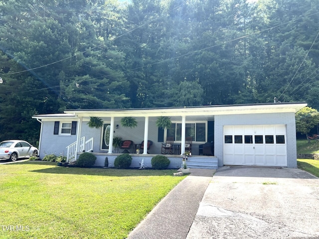 view of front of home with driveway, brick siding, covered porch, and a front yard