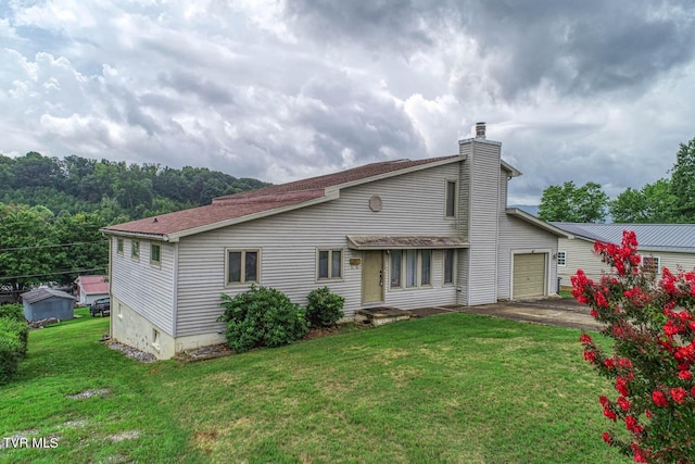 back of property with a garage and a yard