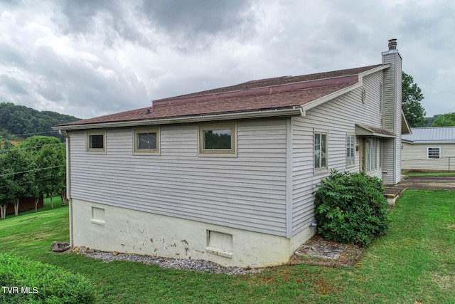 view of side of home with a yard