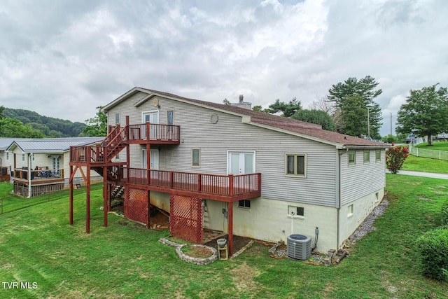 rear view of property with a wooden deck, a lawn, and central air condition unit