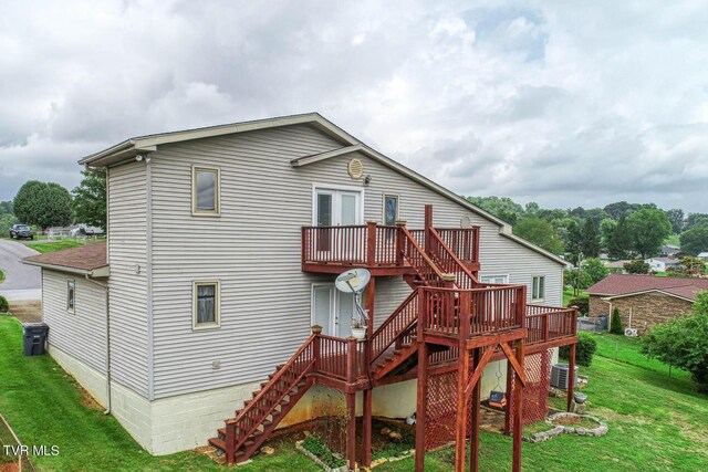 back of property with a deck and a lawn