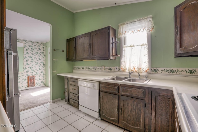 kitchen featuring dishwasher, sink, ornamental molding, light tile patterned floors, and dark brown cabinets