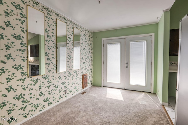 interior space with light carpet, french doors, and ornamental molding