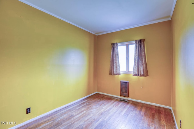 spare room with wood-type flooring and ornamental molding