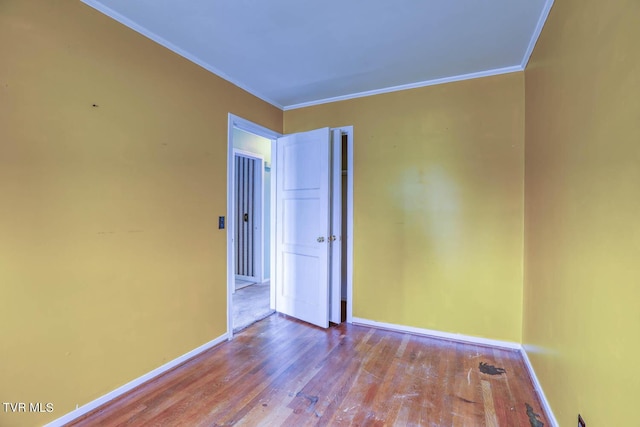 spare room with crown molding and hardwood / wood-style floors