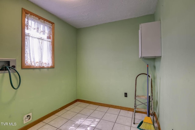 clothes washing area featuring washer hookup, a textured ceiling, and light tile patterned floors