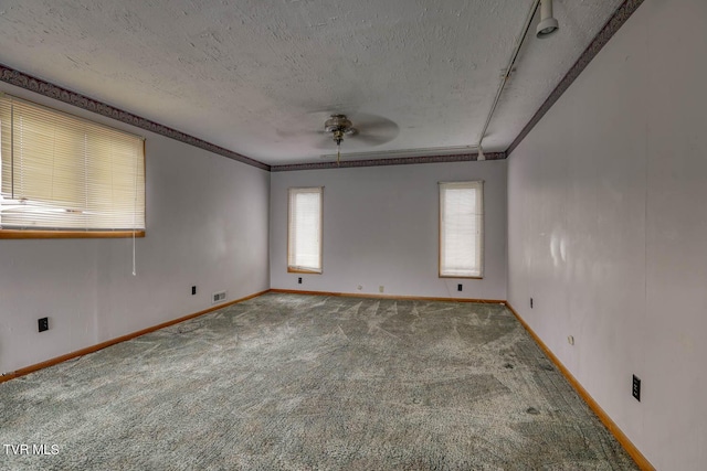 carpeted spare room featuring ceiling fan, crown molding, and a textured ceiling