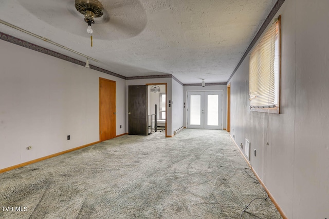 interior space with carpet flooring, crown molding, french doors, and ceiling fan