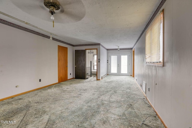 unfurnished room featuring carpet flooring, ceiling fan, crown molding, a textured ceiling, and french doors