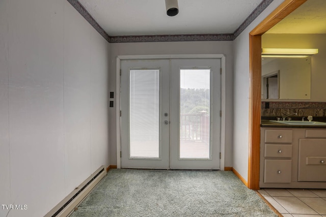 doorway to outside featuring ornamental molding, sink, a baseboard heating unit, french doors, and light tile patterned floors