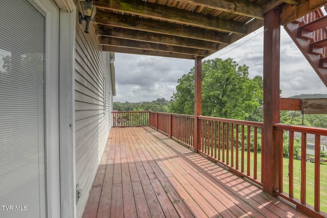 wooden terrace featuring a lawn