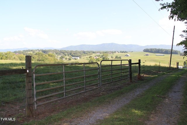 view of gate featuring a rural view, a mountain view, and fence