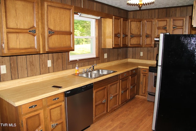 kitchen with wooden walls, appliances with stainless steel finishes, brown cabinets, light countertops, and a sink