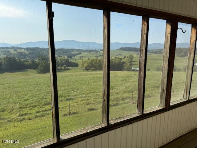 interior space featuring a wealth of natural light, a rural view, and a mountain view