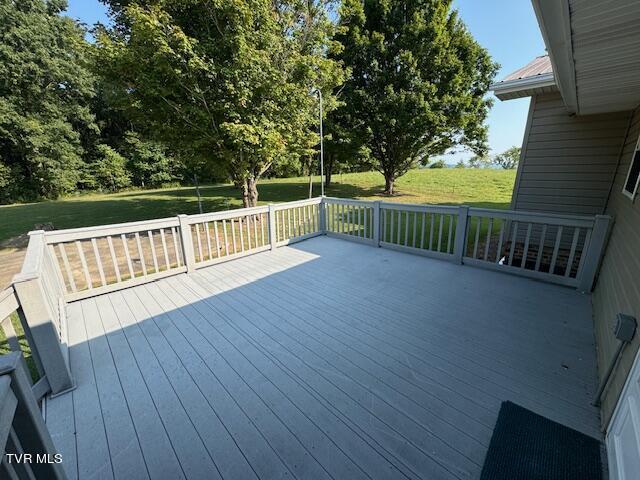 wooden terrace featuring a lawn