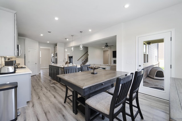 dining space featuring sink, light hardwood / wood-style flooring, and ceiling fan