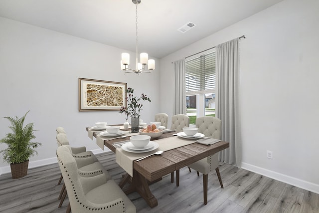 dining area with an inviting chandelier and wood-type flooring