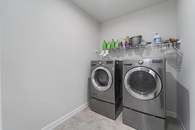 clothes washing area with light tile patterned flooring and washer and clothes dryer